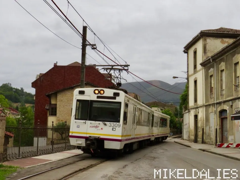 Tren 3309-3310 de FEVE pasando un paso a nivel antes de entrar en la estación de Infiesto en la línea de cercanías Oviedo-Infiesto
